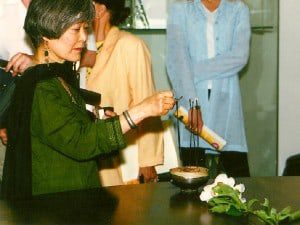 Mira Nakashima lighting incense in a Toshiko Takaezu bowl before the ceremony.