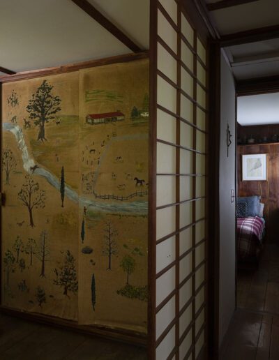 Above exterior and Interior hall with view of bedrooms. Photos by Elizabeth Felicella, 2020